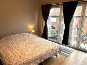 een slaapkamer met een bed en een groot raam bij Home Trietje in Gent
