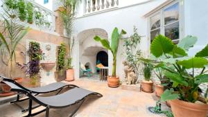 a patio with a bunch of plants and a chair at Nomadara - Boutique B&B in Coín