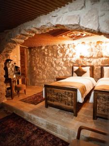 a bedroom with a bed in a stone wall at Lost City Cappadocia Cave Hotel in Nar