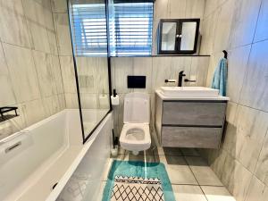 斯科特堡的住宿－Seewindelaan，浴室配有卫生间、盥洗盆和浴缸。