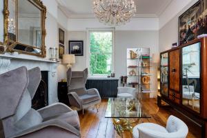 a living room with a fireplace and chairs and a chandelier at Veeve - Crystal Clear in London