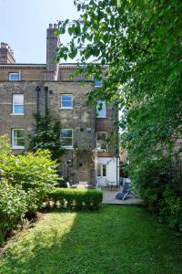 a large brick building with a lawn in front of it at Veeve - Crystal Clear in London