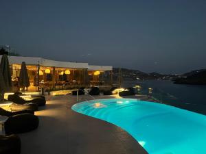 a swimming pool on top of a building at night at Panormos Village Hotel in Mykonos