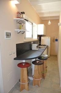 a kitchen with a counter with stools in it at Dimora Cavalieri charming house salento puglia in Andrano