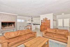 a living room with two couches and a fireplace at 82 on Main in Agulhas