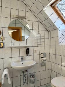 a white bathroom with a sink and a mirror at Heitmann`s Gasthof in Kirchlinteln