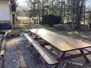 una mesa de picnic de madera sentada en un patio en Au p’tit paradis, en Fresse