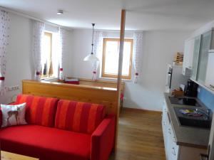 a living room with a red couch and a kitchen at Appartement Romana - Altstadt in Schladming