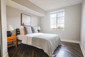 a white bedroom with a bed and a window at Huge & Bright 3BDR & 2BTH in SM - Free Parking in Los Angeles