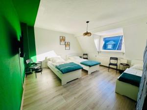 ハーゲンにあるUrban Green Appartement Hagenの緑の壁のベッドルーム1室(ベッド2台付)