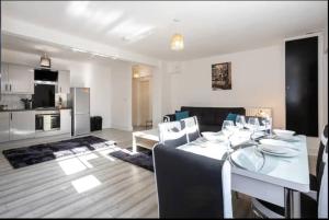 een eetkamer en een woonkamer met een tafel en stoelen bij Devonshire Road - Apartment 1 in Birkenhead