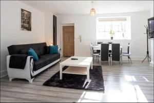 een woonkamer met een bank en een tafel bij Devonshire Road - Apartment 1 in Birkenhead