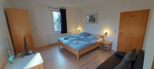 1 dormitorio con cama y sofá en Pension am Bach, en Stützerbach