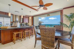 Una cocina y un comedor con mesa y sillas. en Ko Olina Beach Villas O904, en Kapolei