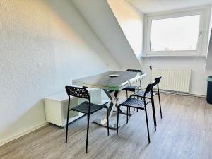 een tafel en stoelen in een kamer met een raam bij Urban Green Appartement Hagen in Hagen