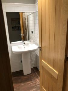 La salle de bains est pourvue d'un lavabo blanc et d'un miroir. dans l'établissement Las Hortensias, à Naves