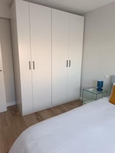 a white bedroom with white cabinets and a bed at Bautiful and centrally located, Cuzco-Bernabeu in Madrid