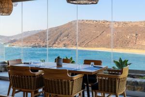 a table and chairs with a view of the ocean at Panormos Village Hotel in Mykonos