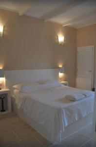 a bedroom with a large white bed with two lights at Dimora Cavalieri charming house salento puglia in Andrano