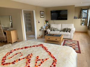 um quarto com uma cama grande com um coração vermelho em The Penthouse Bowness Luxury Loft Jacuzzi Bath & Complimentary Lakeview Spa Membership em Bowness-on-Windermere