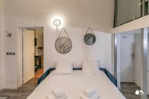 ein Schlafzimmer mit einem Bett mit drei Kissen darauf in der Unterkunft MBA Splendide Appart - Tracy 1 - Proche du Musée du Louvre in Paris