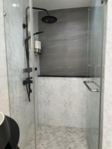 W łazience znajduje się prysznic ze szklanymi drzwiami. w obiekcie Quinstel Hostel w mieście Bangkok