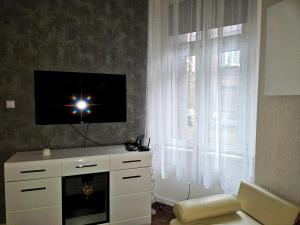 ein Wohnzimmer mit einem TV und einem Fenster in der Unterkunft Apartament Moniuszki Starówka Bytom 40m2 in Bytom