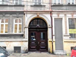 un edificio con una porta in legno e un arco di Apartament Moniuszki Starówka Bytom 40m2 a Bytom