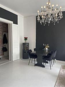 a dining room with a black table and chairs at Cozy room by Royal Palace in Oslo