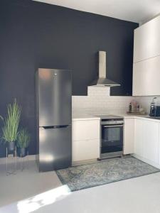 a kitchen with a stainless steel refrigerator and a stove at Cozy room by Royal Palace in Oslo