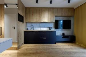 una cucina con armadi in legno e piano di lavoro nero di Studio Apartment - Odra View&Witolda a Breslavia