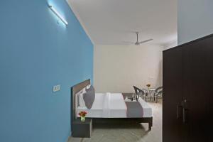 1 dormitorio con 1 cama y 1 mesa con sillas en OYO Rajvanshi Residency, en Gurgaon