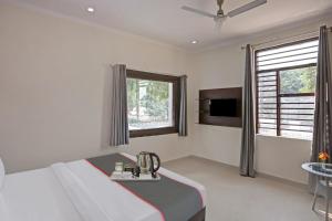 a hotel room with a bed and a window at OYO Rajvanshi Residency in Gurgaon