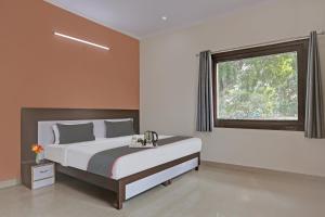 a bedroom with a large bed and a window at OYO Rajvanshi Residency in Gurgaon
