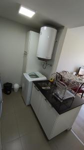 a kitchen with a sink and a white refrigerator at Santiago in Paraná