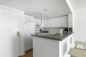 cocina con armarios blancos y encimera negra en South Beach 1br w sun deck gym nr waterfront SFO-1658, en San Francisco