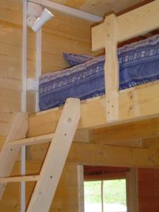 a bedroom with two bunk beds in a log cabin at Le Repaire de Mitzerlé in Mitzach