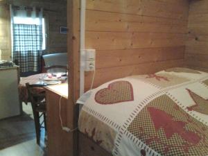 a bedroom with a bed and a wooden wall at Le Repaire de Mitzerlé in Mitzach