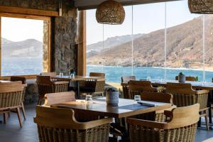 a restaurant with tables and chairs and a view of the ocean at Panormos Village Hotel in Mykonos