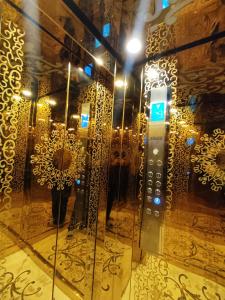 a elevator in a room with a wall of gold at Royal Reside in Rawalpindi