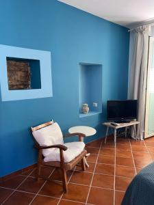 un soggiorno con pareti blu, una sedia e un tavolo di Suite I Limoni a Ravello