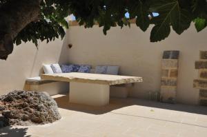 a bench sitting under a tree with pillows on it at Dimora Cavalieri charming house salento puglia in Andrano