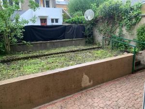a garden with a green railing and a fence at Magnifique cosy a 10 min de la place Ducale in Charleville-Mézières