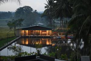 una casa en un lago con luces encendidas en Samkara Restaurant and Garden Resort, en Majayjay