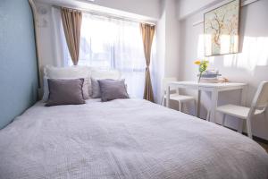 a bedroom with a bed and a table and a window at 2min walk to Higashi Shinjuku Sta SiEW in Tokyo