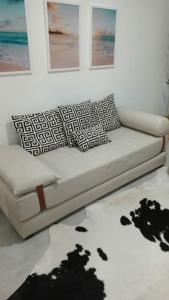 een witte bank met kussens in de woonkamer bij Loft Maria Helena I in Vila Velha