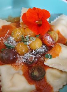 a plate of food with grapes and flowers on it at La Lézardière in Pleugriffet