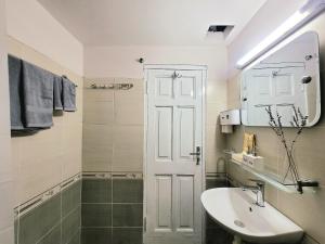 uma casa de banho branca com um lavatório e um espelho em Tiny homes Ba Đình 02 em Hanói
