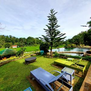 a garden with chairs and a table and a pond at Samkara Restaurant and Garden Resort in Majayjay