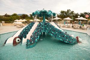 a water slide in a pool at a resort at Trypiti Resort Blue Dream Palace and Hive Water Park in Limenaria